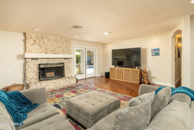 living room featuring french doors, hardwood / wood-style flooring, and a fireplace