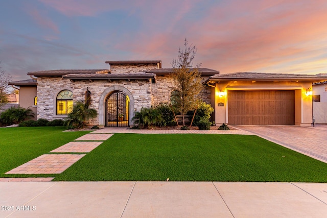 view of front of property featuring a garage and a lawn