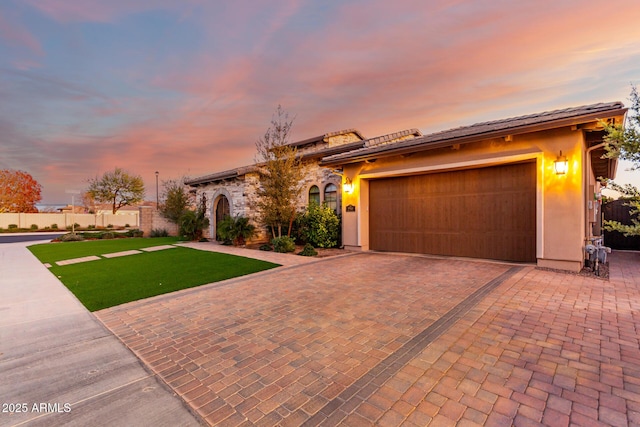 mediterranean / spanish-style home with a garage and a lawn