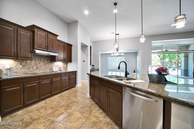 kitchen featuring pendant lighting, dishwasher, tasteful backsplash, and sink