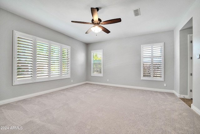 carpeted spare room with plenty of natural light and ceiling fan