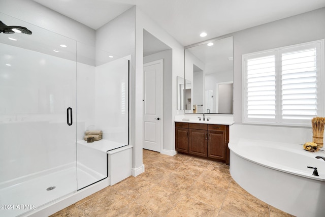 bathroom with a wealth of natural light, vanity, and shower with separate bathtub