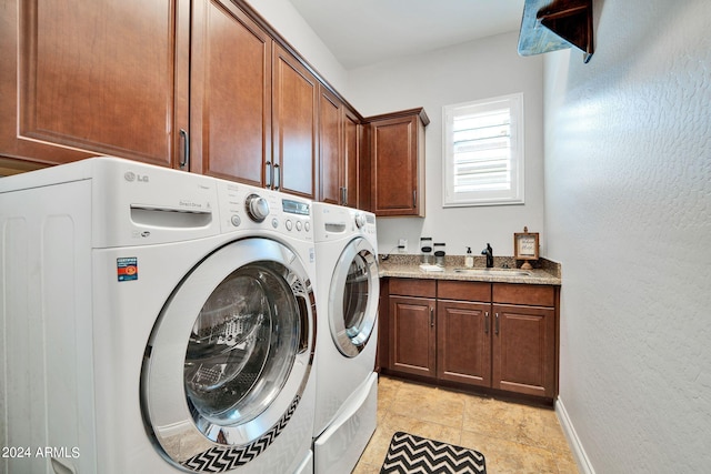 clothes washing area featuring sink, cabinets, and washing machine and dryer