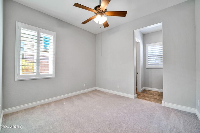 carpeted spare room featuring ceiling fan