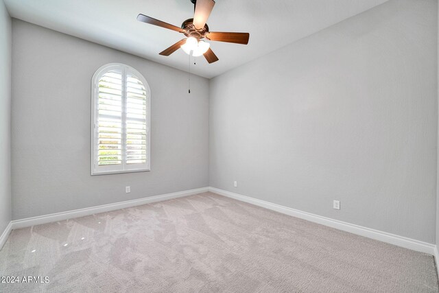 spare room featuring light colored carpet and ceiling fan