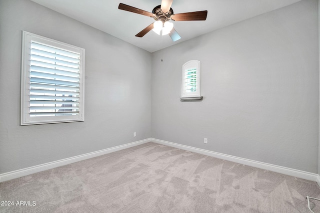 carpeted spare room featuring ceiling fan