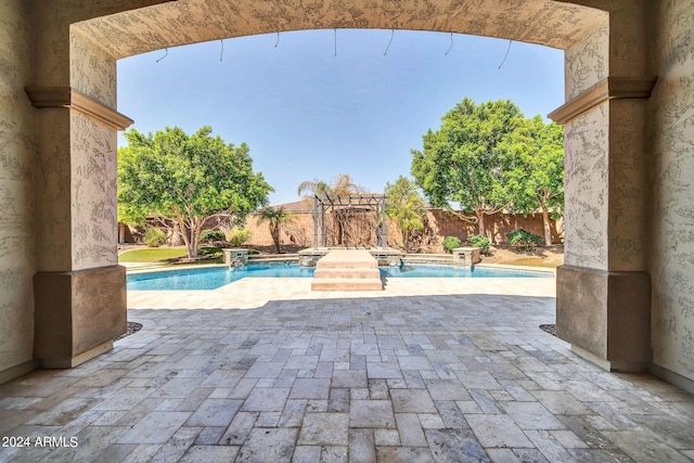 view of swimming pool with pool water feature and a patio area