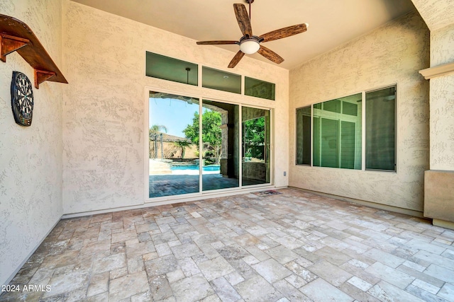 unfurnished sunroom featuring ceiling fan