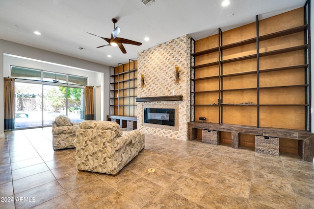 living room with ceiling fan and a large fireplace