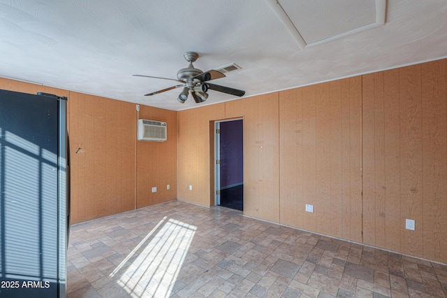 spare room with a wall unit AC, wooden walls, and ceiling fan