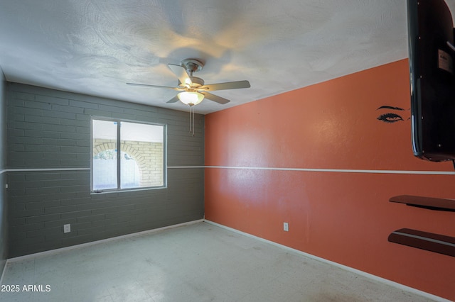 spare room with brick wall and ceiling fan