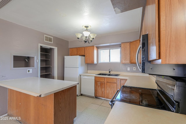 kitchen featuring white appliances, kitchen peninsula, an inviting chandelier, and sink