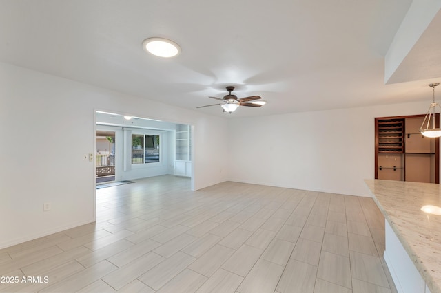 unfurnished living room featuring a ceiling fan, french doors, built in features, and baseboards