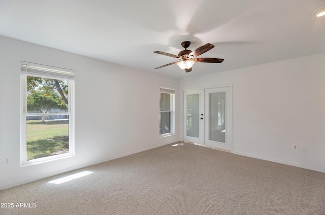 carpeted empty room with ceiling fan, baseboards, and french doors