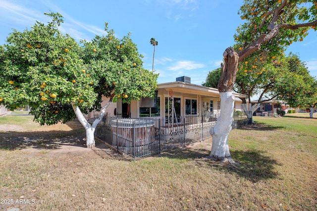 view of front facade with a front lawn and fence