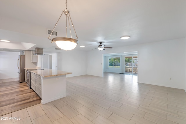 kitchen with stainless steel appliances, visible vents, open floor plan, wall chimney exhaust hood, and decorative light fixtures