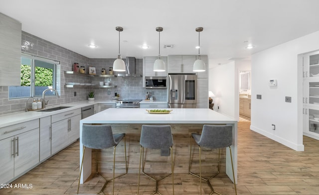 kitchen with light wood-type flooring, appliances with stainless steel finishes, and a center island