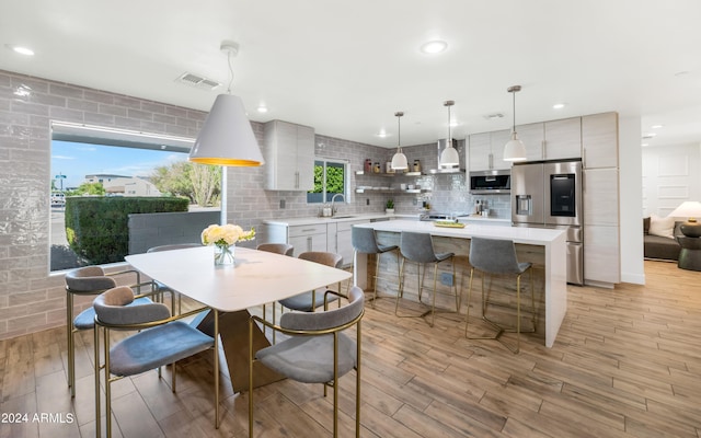 dining area with sink and light hardwood / wood-style floors