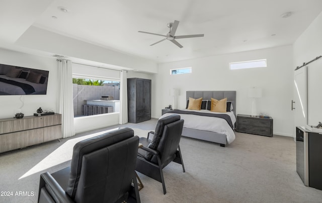 carpeted bedroom featuring ceiling fan and a barn door