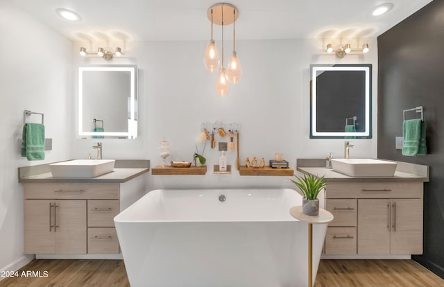 bathroom featuring hardwood / wood-style flooring, a tub to relax in, and vanity