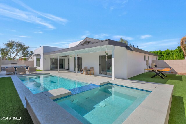 view of swimming pool with ceiling fan, a patio, and a lawn