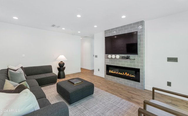 living room featuring light hardwood / wood-style flooring and a large fireplace