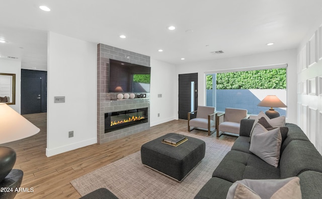 living room featuring light hardwood / wood-style flooring and a large fireplace