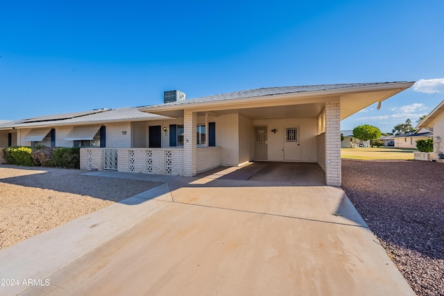 view of front of home featuring a porch, a carport, and central air condition unit