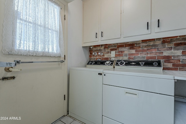 clothes washing area featuring cabinets and washing machine and dryer