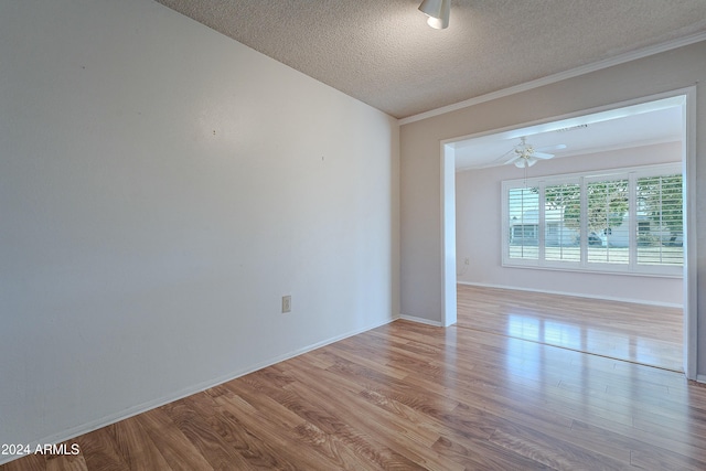 spare room with ornamental molding, a textured ceiling, and light wood-type flooring