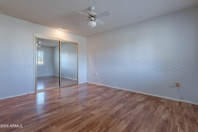 unfurnished bedroom with hardwood / wood-style flooring, ceiling fan, a textured ceiling, and a closet