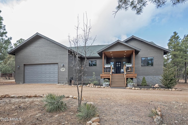 view of front of house with a garage, stairs, and dirt driveway