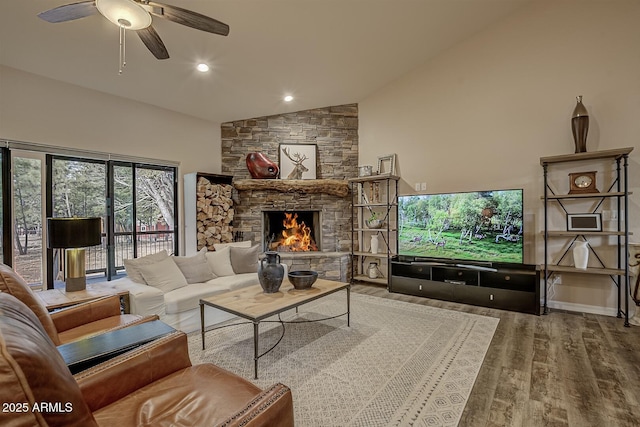 living room featuring ceiling fan, high vaulted ceiling, a fireplace, and wood finished floors