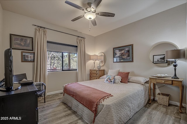 bedroom with wood finished floors, a ceiling fan, and baseboards