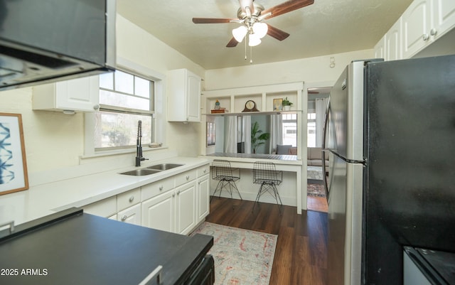 kitchen featuring sink, dark hardwood / wood-style floors, stainless steel fridge, ceiling fan, and white cabinets