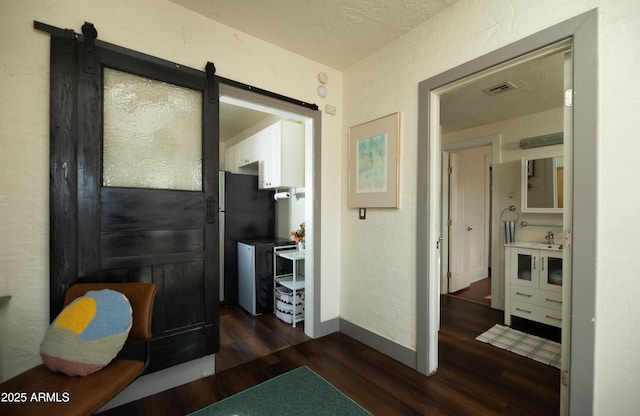 corridor featuring dark hardwood / wood-style floors and a barn door