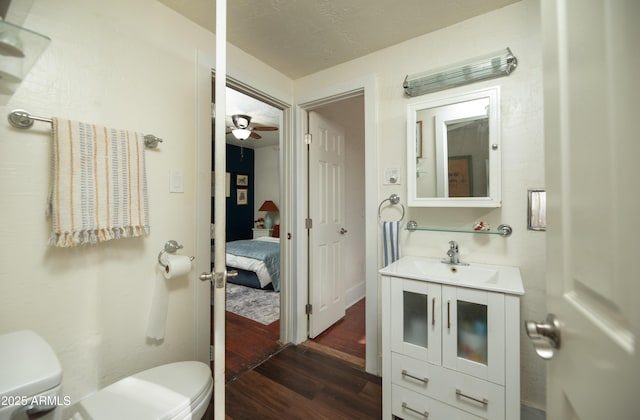 bathroom with vanity, ceiling fan, wood-type flooring, and toilet