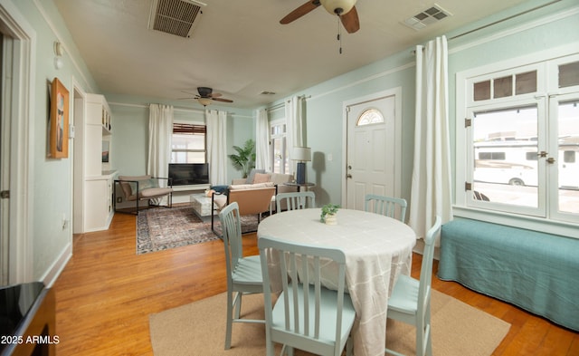 dining space with light hardwood / wood-style floors and ceiling fan