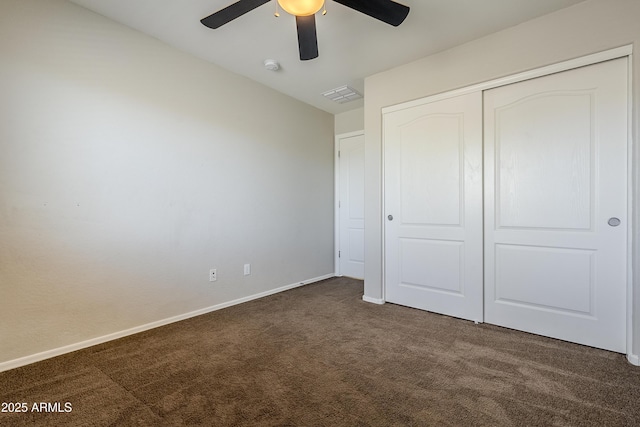 unfurnished bedroom with a closet, ceiling fan, and dark colored carpet