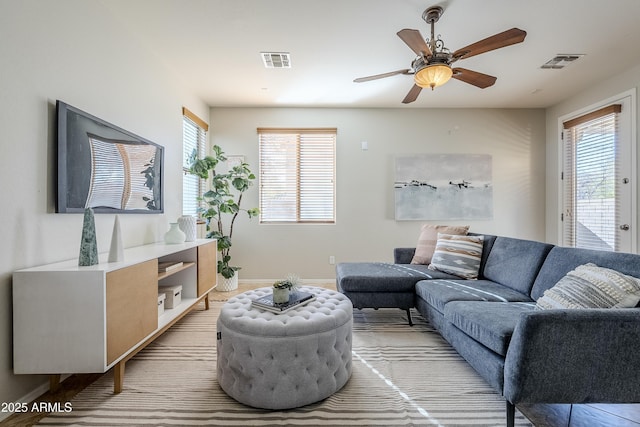 living room with ceiling fan and a wealth of natural light