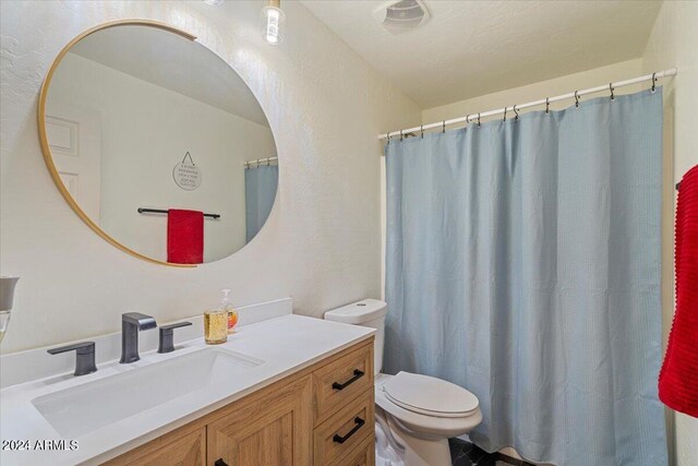 bathroom with walk in shower, vanity, and toilet