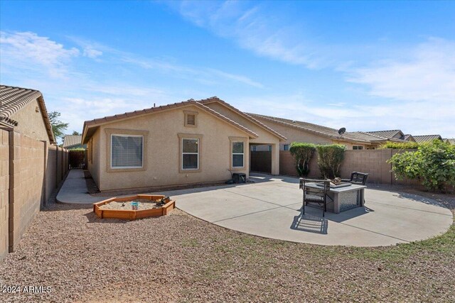 rear view of property with a patio area and an outdoor fire pit