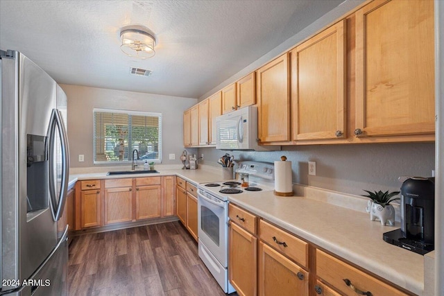 kitchen with white appliances, a textured ceiling, dark hardwood / wood-style floors, and sink