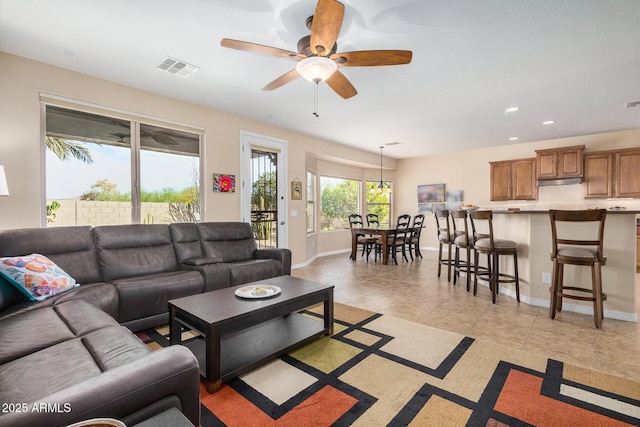 tiled living room with ceiling fan