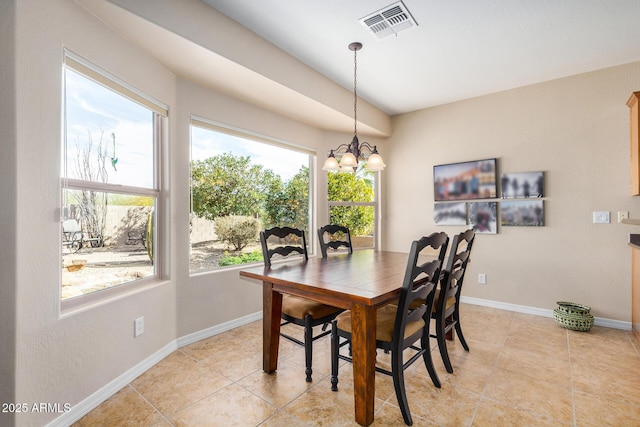 tiled dining area featuring a chandelier