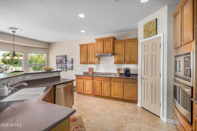 kitchen with stainless steel appliances, decorative light fixtures, and sink