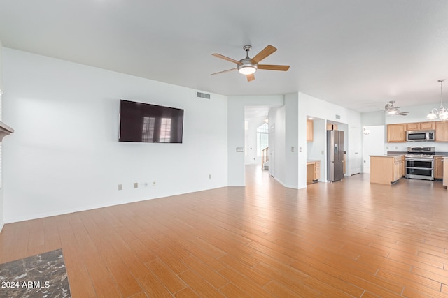 unfurnished living room with light hardwood / wood-style floors and ceiling fan with notable chandelier