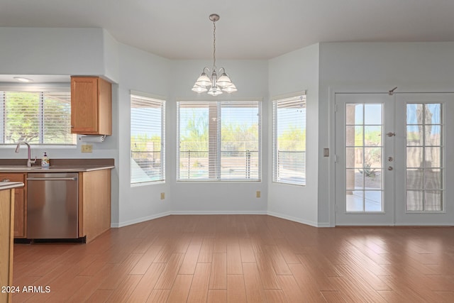 kitchen with light hardwood / wood-style floors, french doors, dishwasher, and hanging light fixtures