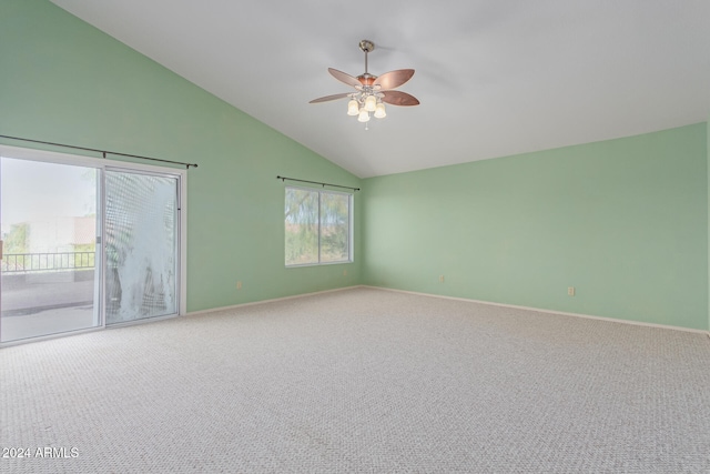 carpeted spare room with ceiling fan and vaulted ceiling