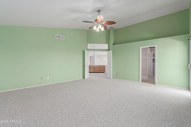 unfurnished room with lofted ceiling, light colored carpet, and ceiling fan